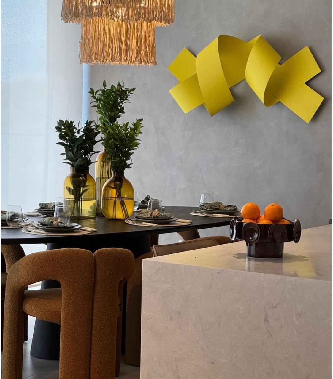 Comedor con sillas en bouclé óxido y escultura amarilla