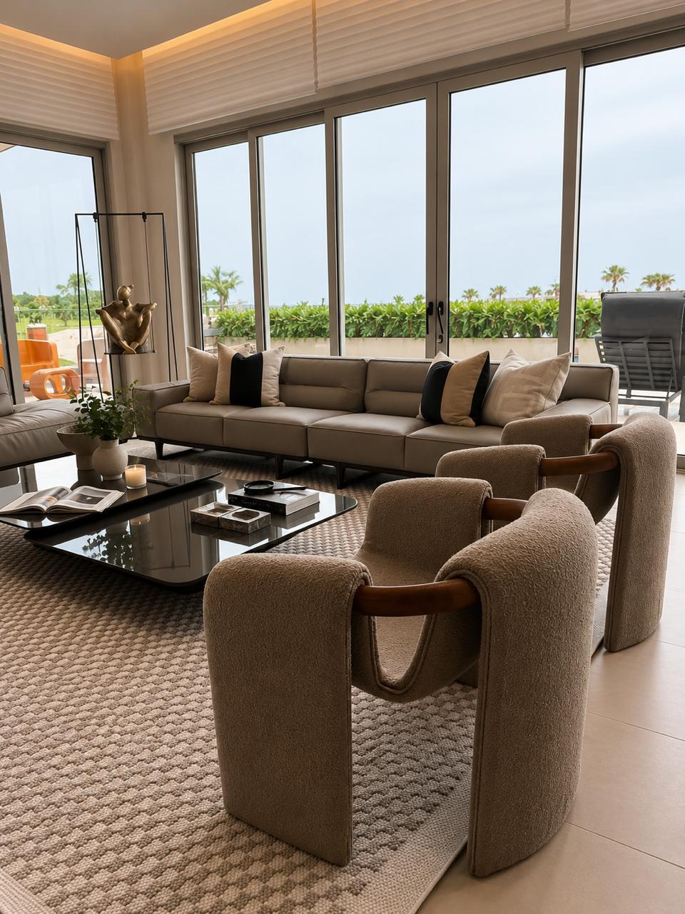 Sala frente al mar con sofá de cuero y ventanales de piso a techo
