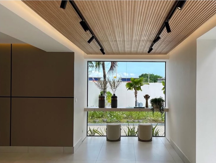 Pasillo de lobby con cielo raso de listones de madera y ventanal
