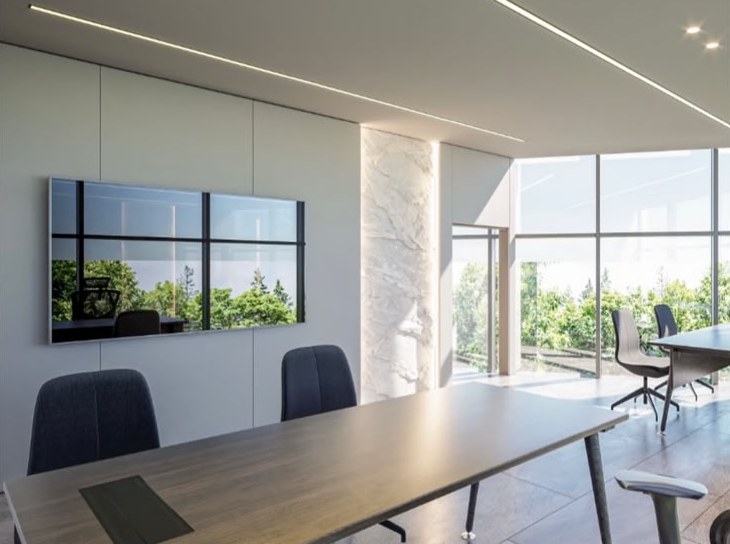 Sala de reuniones con mesa de madera y ventanales hacia vegetación