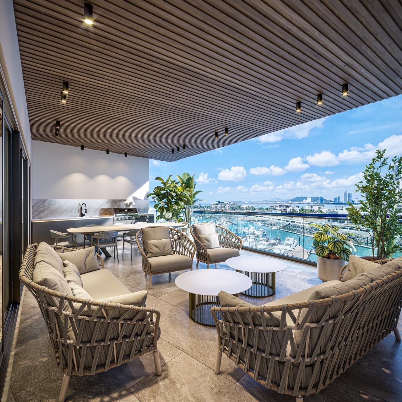Terraza techada con muebles tejidos, cocina exterior y vista a la marina