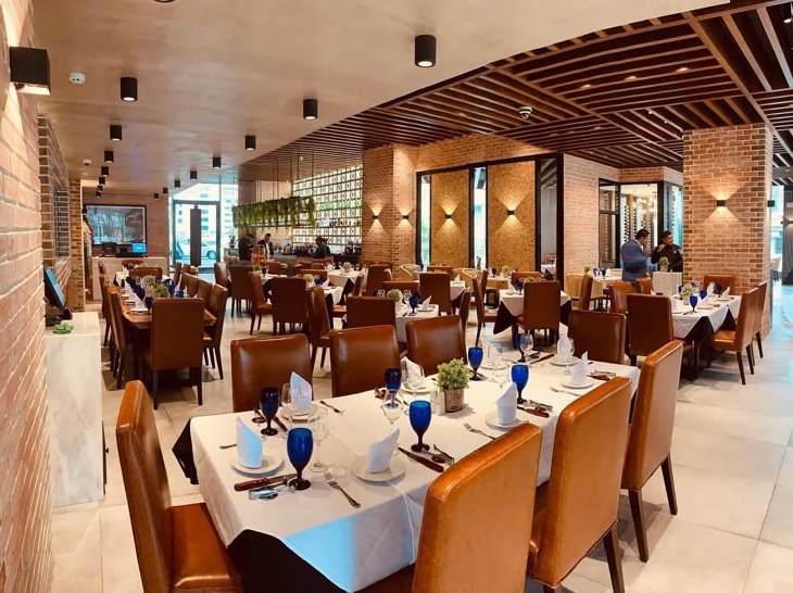 Salón principal de Texas de Brazil con muros de ladrillo y sillas de cuero